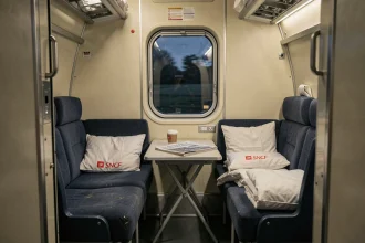 Intérieur d'un compartiment couchette de train de nuit SNCF avec literies bleues et blanche, ambiance nostalgique et feutrée