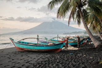 Plage de sable noir de Lovina à Bali avec des bateaux de pêche traditionnels jukung au lever du jour
