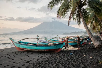 Plage de sable noir de Lovina à Bali avec des bateaux de pêche traditionnels jukung au lever du jour